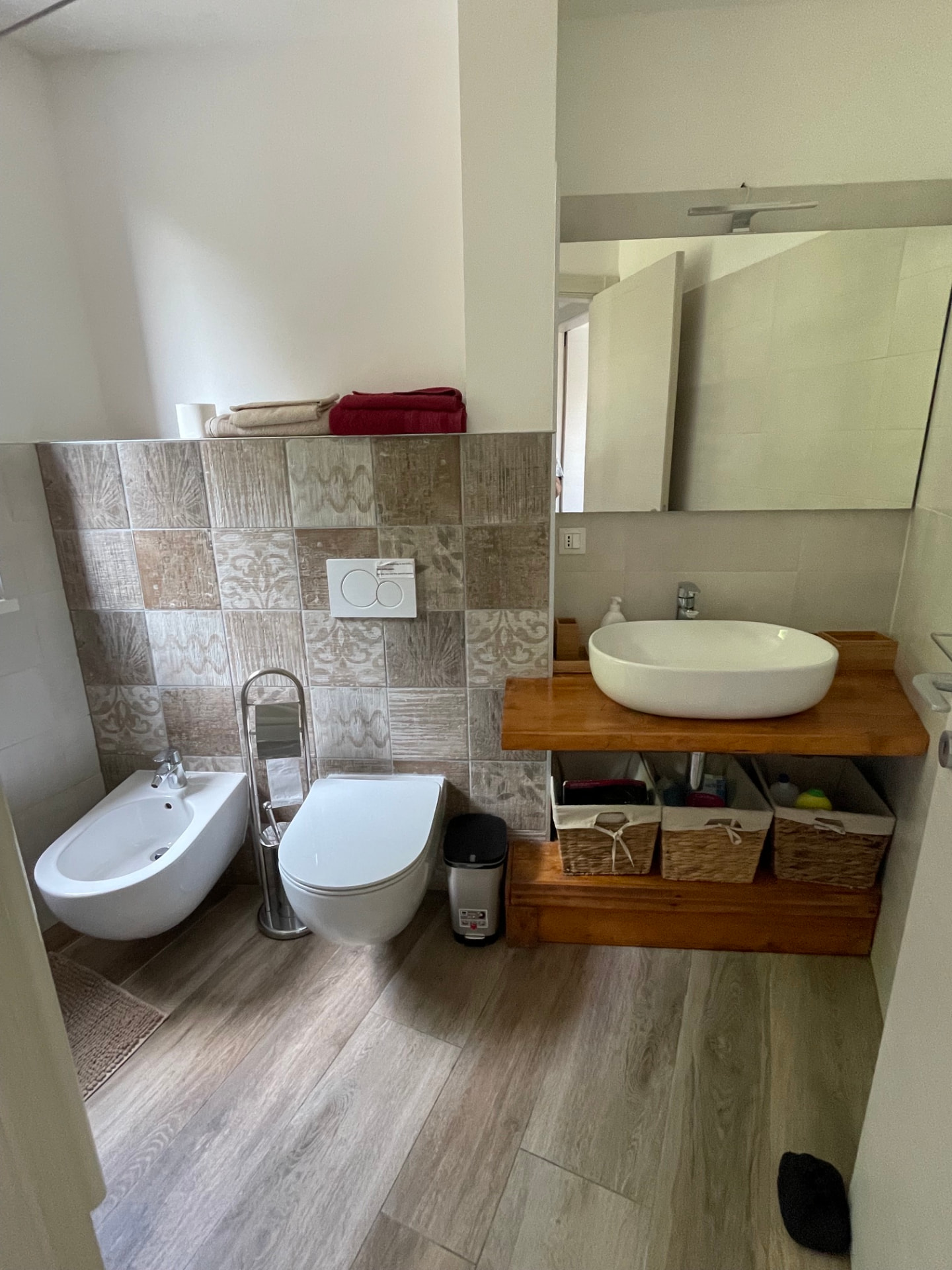 Bagno con lavabo d'appoggio su mensola in legno